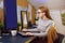 Stay home, a chic girl works in a homely atmosphere. Girl freelancer working at a computer with glasses, looking at a green screen