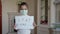 Stay at home concept. Small girl in mask holding sign saying stay at home for virus protection and take care of their