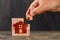 Stay at home concept on wooden background side view. hand holding wooden cube