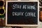 Stay at home drink coffee. Words on blackboard flat lay