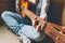 Stay Home Stay Safe. Young woman sitting at home and playing guitar, hands close up. Teen girl learning to play song and writing