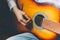 Stay Home Stay Safe. Young woman sitting at home and playing guitar, hands close up. Teen girl learning to play song and writing