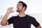 Stay hydrated. Cropped shot of a handsome young male athlete hydrating during his workout on the beach.