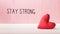 Stay Strong message with a red heart cushion
