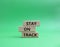 Stay on track symbol. Wooden blocks with words Stay on track. Beautiful green background. Business and Stay on track conce