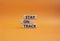 Stay on track symbol. Wooden blocks with words Stay on track. Beautiful orange background. Business and Stay on track conc