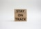 Stay on track symbol. Wooden blocks with words Stay on track. Beautiful white background. Business and Stay on track conce