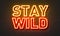 Stay wild neon sign on brick wall background.