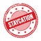 STAYCATION text written on red grungy round stamp