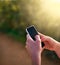 Staying connected on the move. Shot of an unidentifiable woman sending a text message while in a park.