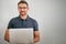 Staying in the loop with whats happening online. a man using a laptop against a gray background.