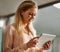 Staying up to date in business. a smiling young businesswoman working on a digital tablet in an office.