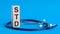 Std word written on wooden blocks and stethoscope on light blue background