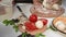 Steadicam shot: Fresh organic pizza ingredients on a kitchen table against a cook hands kneading dough in rustic kitchen