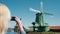 Steadicam shot: woman takes pictures of old windmills in Zaans Schans