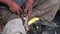 Steady close up shot of cobbler repairing an old torn  slippers.