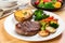 steak, baked potato, and vegetable medley on white plate