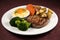 steak, baked potato, and vegetable medley on white plate