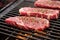 steak on grill grates with peppercorns scattered around