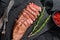 Steak of marbled beef roasting medium on a black stone Board. Black background. Top view