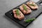 Steaks in marinade on wooden board and grey background