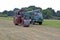 A steam engine and a old retro emergency truck having a race in a field