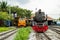 Steam locomotive and Diesel Electric Locomotives parking at train depot of Thailand.