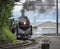 A Steam Locomotive Rounding a Curve Blowing Black Smoke and White Steam