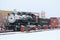 A steam locomotive sits in the snow covered small town