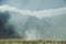 Steam rising from landscape in front of mountains