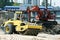 Steam roller and excavator on construction site