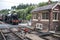 Steam train approaching Levisham historic railway station showing tracks and crossing