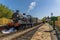 Steam trains passing at a station on a railway line in Sussex, UK