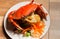 Steamed crab or Boiled crab fresh with crab`s spawn in white dish showing the delicious crab`s eggs inside its shell on wood table