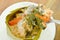 Steamed fish with curry paste stuffed Indian mulberry in coconut cream scooping in spoon