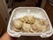 Steamed meat dumplings in white container in kitchen