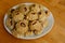 Steamed national Mongolian food dumpling Buuz filled with minced beef, white plate, wooden table, Close up east Siberian Buryats