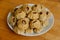 Steamed national Mongolian food dumpling Buuz filled with minced beef, white plate, wooden table, Close up east Siberian Buryats