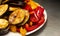 Steamed and roasted vegetables on a barbecue eggplant and red pepper on a plate, close-up