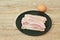 Steamed slice pork bacon arranging on plate and egg