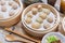 Steamed xiaolongbao and steamed dumplings served in a traditional steaming basket .close up