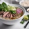 A steaming bowl of pho with thin-sliced beef and fresh herbs1