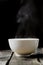 Steaming bowl on rustic wood background