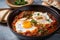 steaming bowl of Shakshuka topped with a dollop of tangy labneh and sprinkled with za atar seasoning