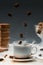 Steaming coffee cup with falling cane sugar cubes by cookies