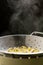 Steaming cooked penne pasta in colander