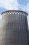 The steaming cooling tower of the winter thermal power station on the background of the blue sky.