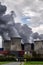 Steaming cooling towers of a power plant with dark gray emission