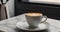 A steaming cup of coffee sits on a white marble countertop, surrounded by roasted beans, in a modern kitchen setting