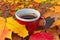 A steaming cup of coffee surrounded by a vibrant array of autumn leaves coffee day generated Ai